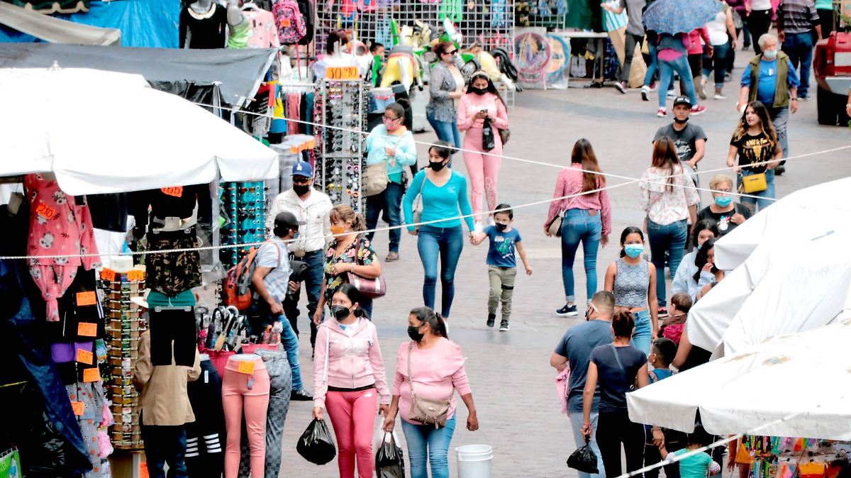 Personas caminando entre comercios portando cubrebocas en la ciudad de Zacatecas; la entidad regresó a color verde en el semáforo epidemiológico